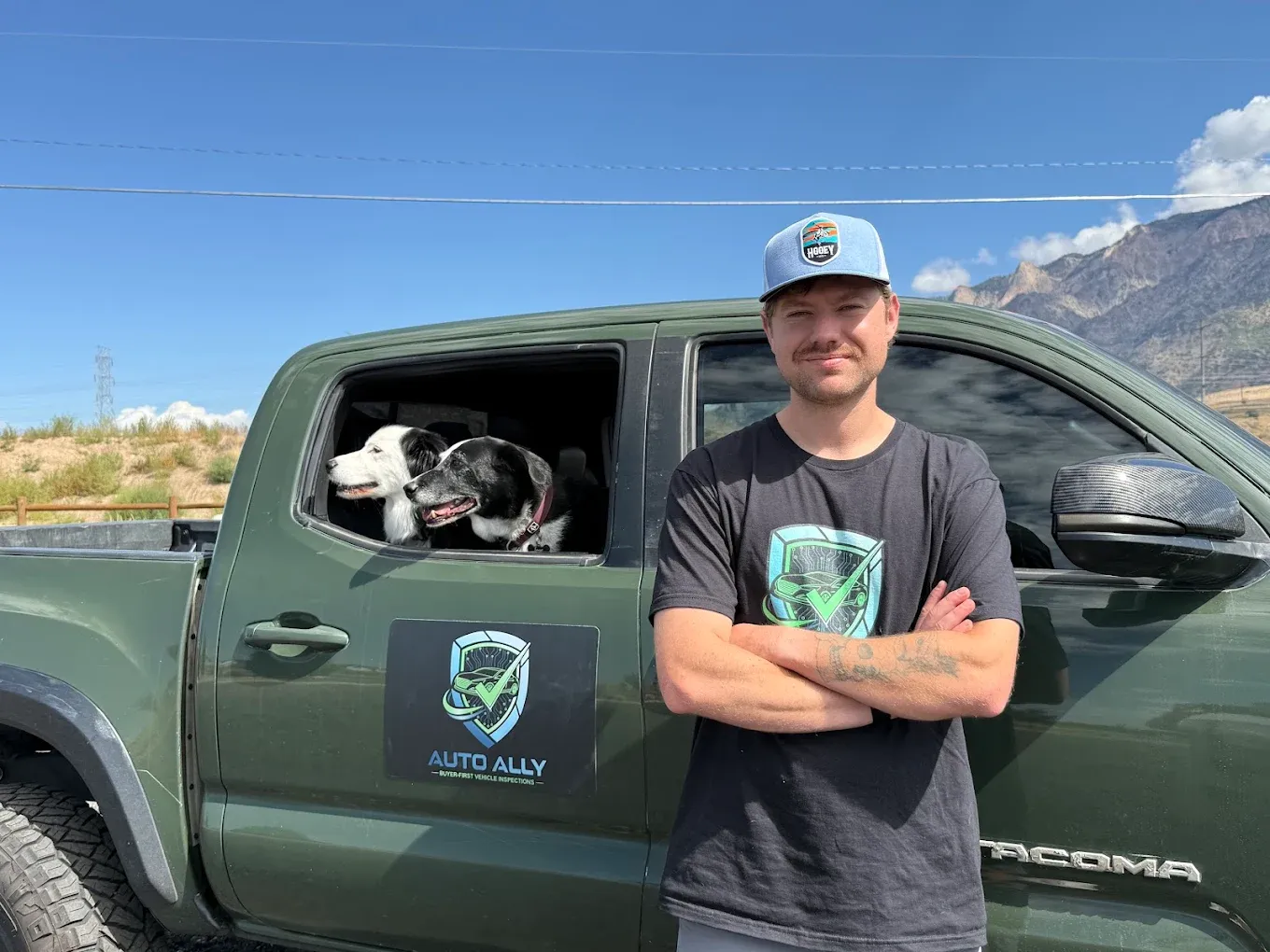 Logan Morris, founder and inspector at Auto Ally, standing beside his Auto Ally truck in Northern Utah with the mountains behind